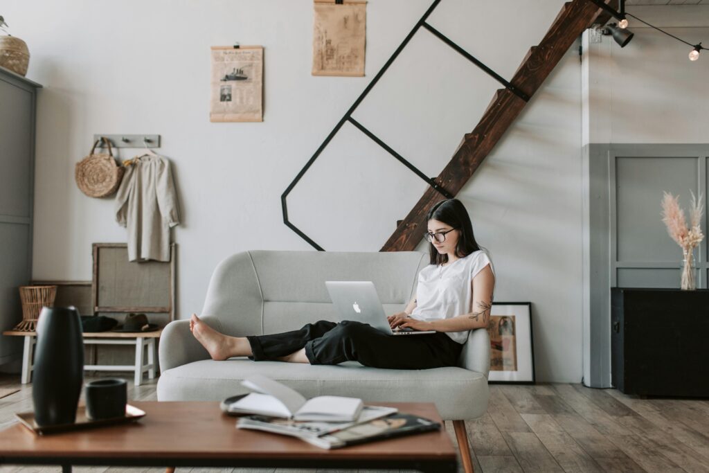 Content young woman using laptop in modern living room